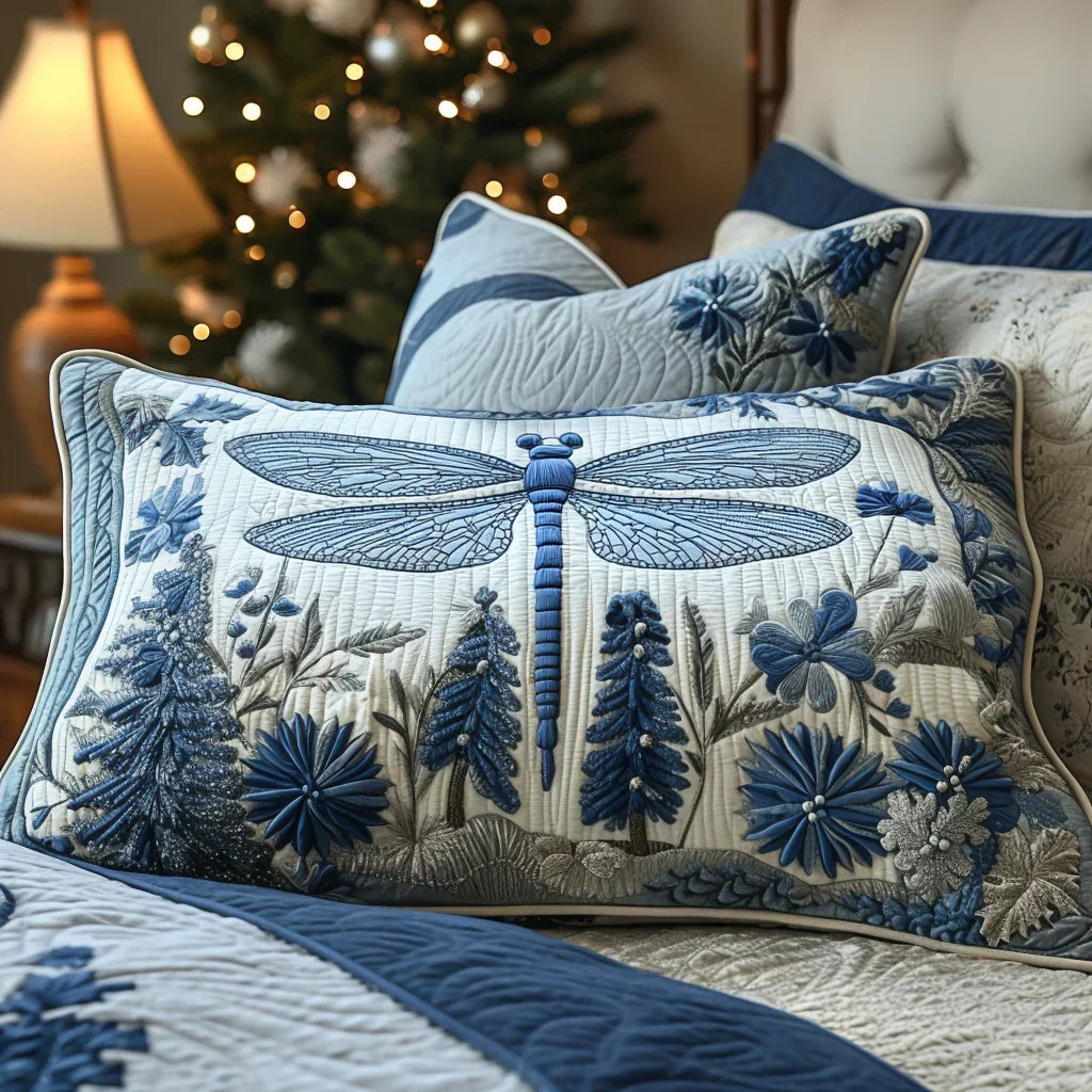 Housse de coussin matelassée à motif d'ailes délicates, posée sur un lit clair – Manon Deauville